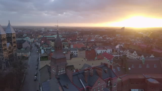 Drohne-Schuss-fliegt-über-Lund-Stadt-bei-Sonnenuntergang.-Domkirche,-die-Gebäude-im-Hintergrund