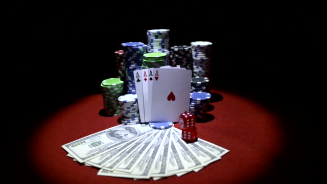 Vier-Asse,-Dollar-und-Stapel-Chips-auf-roten-Casinotisch-Glücksspiel
