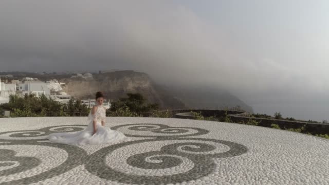 Vista-aérea-de-mujer-con-vestido-de-novia,-isla-de-Santorini,-Grecia.