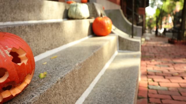 A-scary-carved-pumpkin-Jack-o-Lantern-on-the-steps-of-a-home-before-Halloween-trick-or-treat