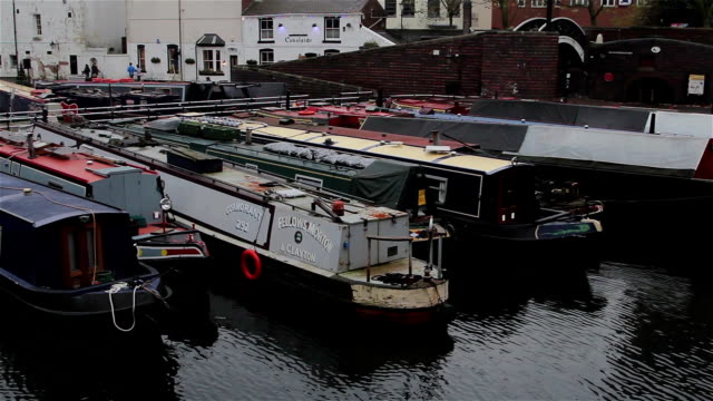 Wide-High-Angle-Pan-of-Narrow-Boats-Docked-in-Canal-Harbor