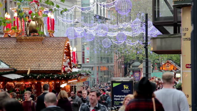 High-Street-luces-parpadeantes-de-navidad-compradores-en-el-concurrido-puesto-de-mercado-navideño-alemán