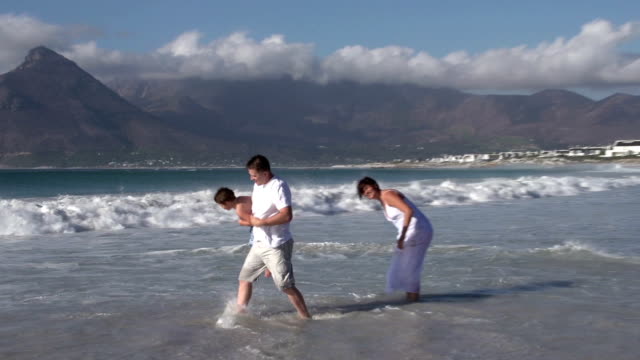 Paar-mit-Kind,-spielen-in-den-Wellen,-Cape-Town