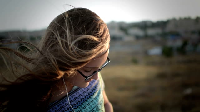 Teenager-Mädchen-mit-eyeglasses-hören-die-Musik-im-Freien