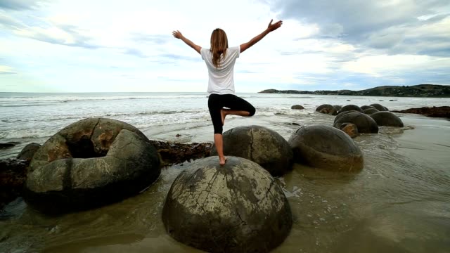 Mujer-de-ejercicios-de-Yoga-en-Boulder-en-el-mar