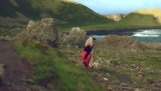 4k-Fantasy-Shot-on-Giant's-Causeway-of-a-Queen-Standing-in-the-Wind