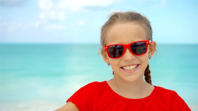 Kleines-Mädchen-unter-Selfie-Porträt-mit-ihrem-Smartphone-am-Strand
