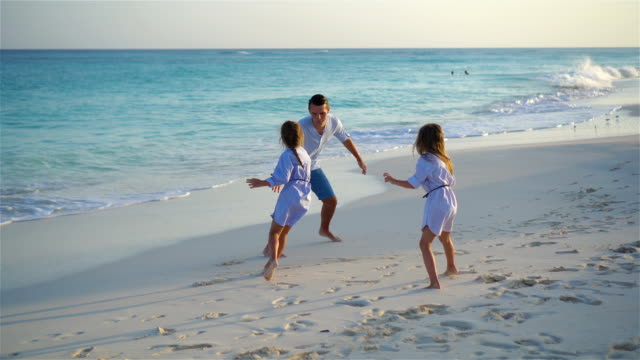 Familie-viel-Spaß-am-weißen-Strand-auf-Karibik-Insel-am-Abend