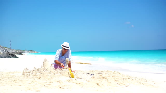 Joven-padre-y-niños-haciendo-castillos-de-arena-en-la-playa-tropical