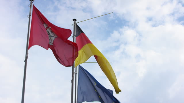 Blick-auf-deutschen-und-europäischen-Flagge,-die-leichte-Brise-vor-blauem-Himmel