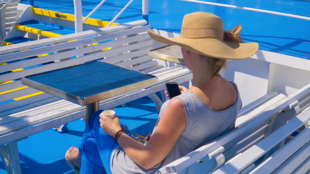 Junge-schöne-Frau-SMS-auf-Smartphone-sitzen-auf-Sitz,-Sommer-Strand-Kleider