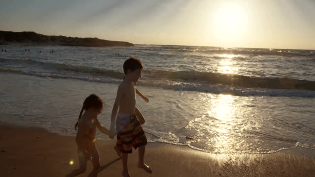 Drei-Kinder-spielen-am-Strand-zusammen