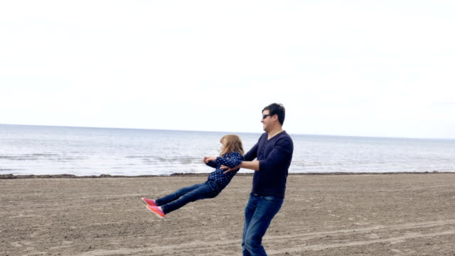 Padre-hija-de-Spinning-en-una-orilla-de-arena-del-lago-Ontario