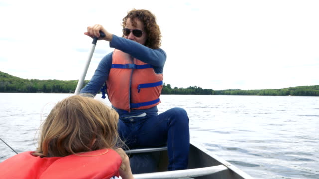 Frau-ein-Ruderboot-mit-einem-Kind-sitzen-vorne