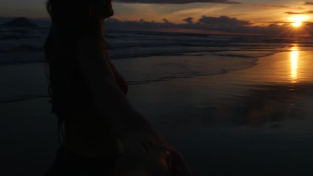 Girlfriend-holding-hands-Boyfriend-at-Sunset-Beach