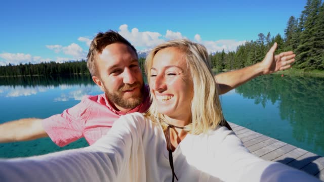 couple-takes-selfies-by-the-lake-on-a-sunny-day