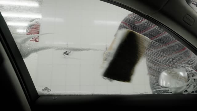 Worker-washing-car-by-foam-sponge