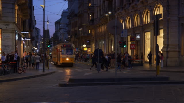 Noche-de-Italia-iluminado-el-panorama-de-Milán-famoso-tranvía-tráfico-cruce-calle-4k