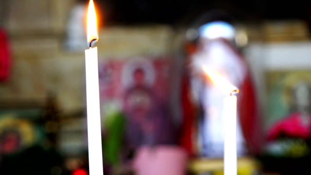 zwei-brennende-langen-weißen-Kerzen-in-der-Nähe-von-Ikonen