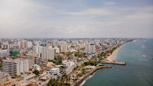 Drone-panning-left-over-amazing-coastline-and-buildings-of-Colombo,-Sri-Lanka.-Amazing-aerial-shot-of-Asian-architecture