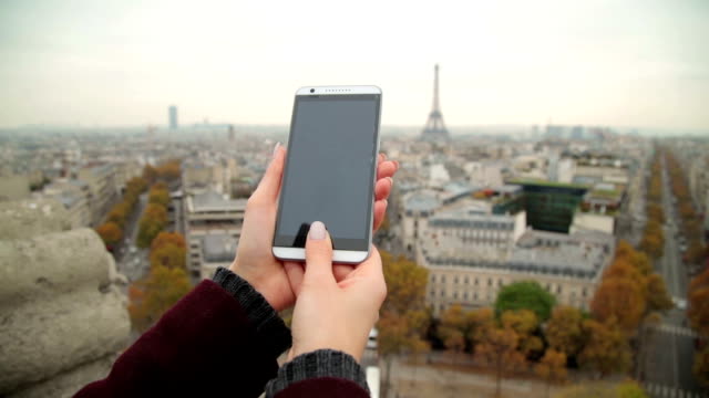 Handy-verwenden-mit-Eiffelturm,-Paris-im-Hintergrund.