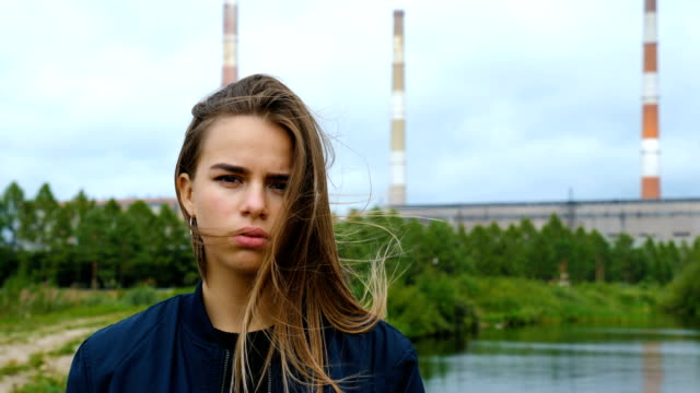 Porträt-eines-jungen-Mädchens-gegen-ein-Wasserkraftwerk.