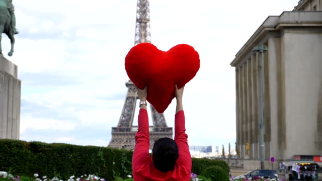 Junge-Frau-drehte-sich-um-vor-Eiffelturm-mit-roten-Herzen-in-ihren-Händen-in-Zeitlupe-180-fps