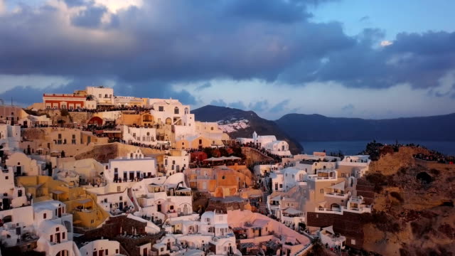 Sobrevuelo-de-la-ciudad-de-Oia-antes-de-puesta-del-sol,-isla-de-Santorini,-Grecia