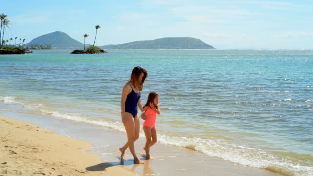 Mother-and-daughter-walking-on-the-beach-4k