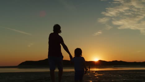 Silhouette-Of-Father-And-Son-Walking-Together-At-Beach