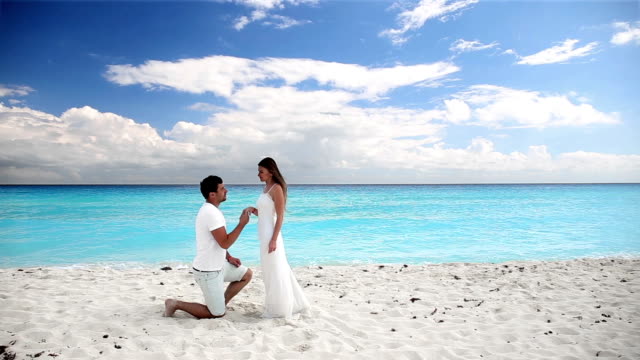 Joven-hermosa-de-recién-casados-hacer-promesas-de-fidelidad-respecto-en-la-playa
