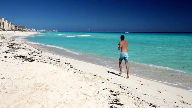 Atlético-hombre-para-correr-en-la-playa-caribeña,-Cancún