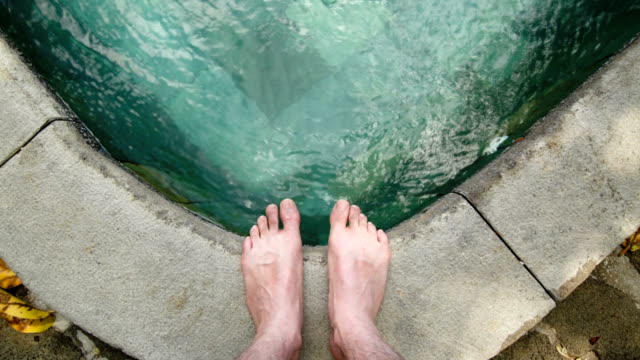 Persona-de-pie-en-la-piscina-con-enfoque-en-los-pies