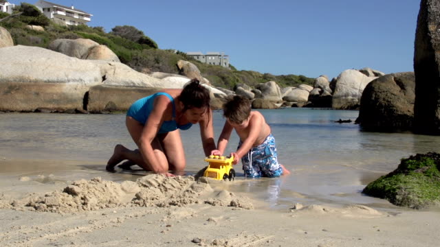 Madre-e-hijo-juegan-en-la-playa-con-los-juguetes,-Cape-Town