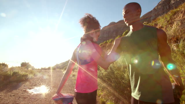 Young-afro-american-couple-warming-up-before-running-outdoors