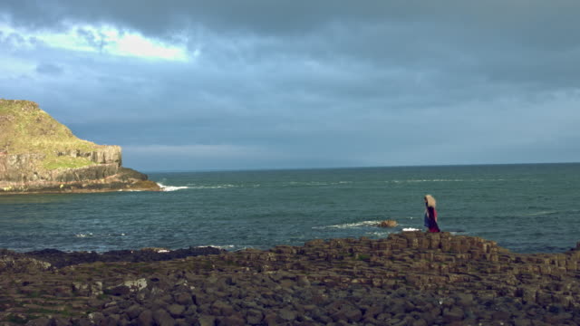 4k-Fantasy-Shot-on-Giant's-Causeway-of-a-Queen-Standing-in-Wind