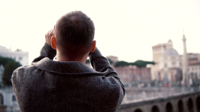 Handsome-man-with-a-beard-exploring-new-city,-taking-photos-of-city-on-smartphone.-Guy-have-vacation-in-Rome,-Italy