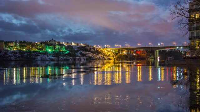 Bridge-and-houses-by-the-water-at-night-4K-Time-Lapse