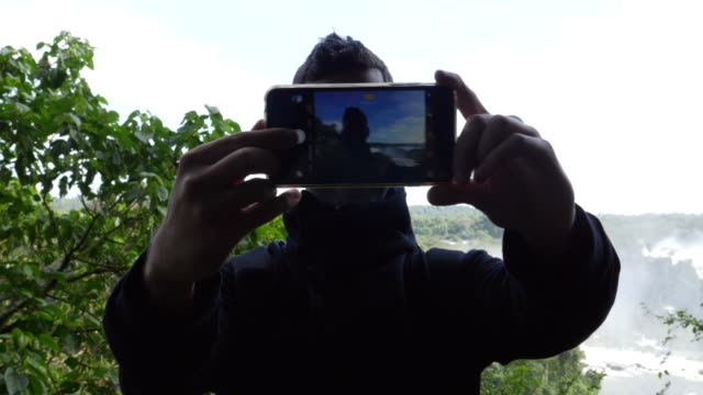 Guy-taking-a-selfie-in-Iguacu-Falls,-Brazil