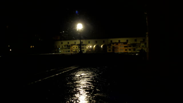 Noche-romántica-pareja-camina-en-ciudad-vacía-de-Florencia-bajo-la-nieve-que-cae