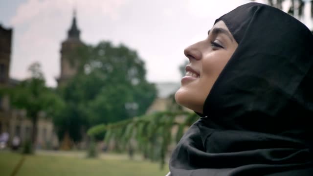 Joven-hermosa-mujer-musulmana-en-hijab-está-mirando-en-el-cielo,-disfrutando-de-tiempo,-concepto-de-epoca