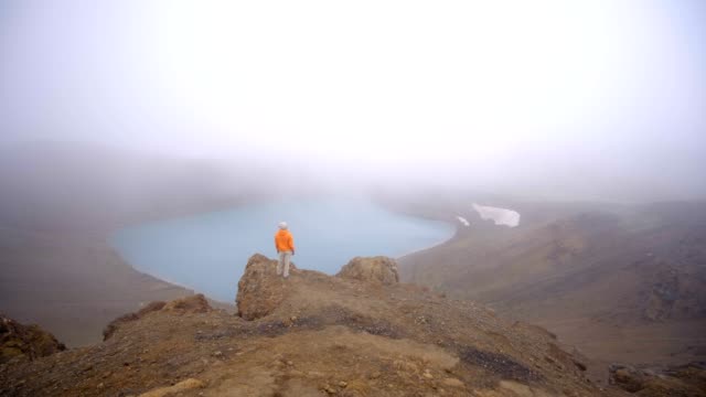 4K-junge-Frau-in-Island-Betrachtung-vulkanische-Kratersee-von-oben-drauf