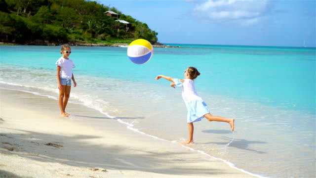 Poco-encantadores-niñas-jugando-con-pelota-en-la-playa