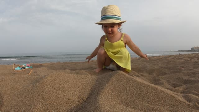 Niedliche-Mädchen-spielen-mit-Sand-am-tropischen-Strand