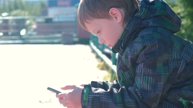 Boy-types-and-sends-a-message-on-a-mobile-phone.