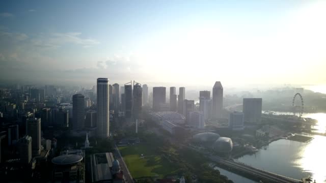 Beautiful-misty-morning-drone-footage-of-Singapore-urban-skyline,-padang-and-esplanade.