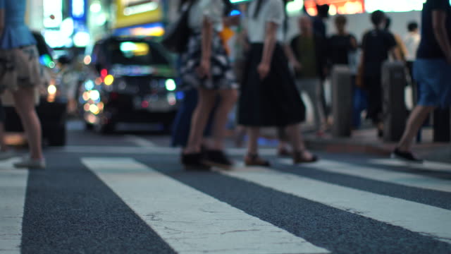 Carretera-cruzando-con-personas-en-la-gran-ciudad-por-la-noche.-Multitud-de-personas-caminando-en-paso-de-peatones-con-brillante-publicidad-vallas-en-tres-antecedentes.