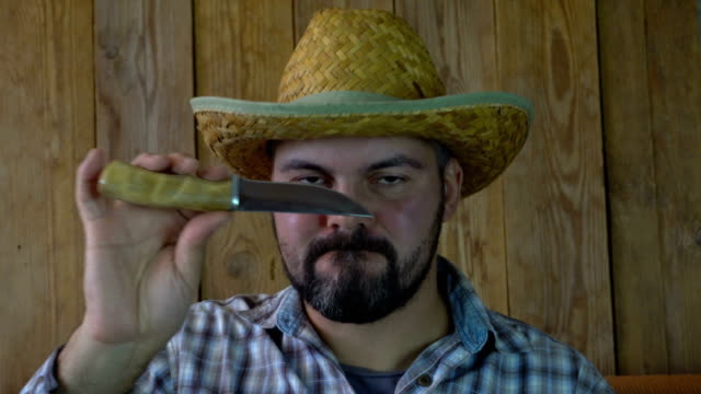 Hombre-barbudo-con-sombrero-de-paja-y-un-cuchillo