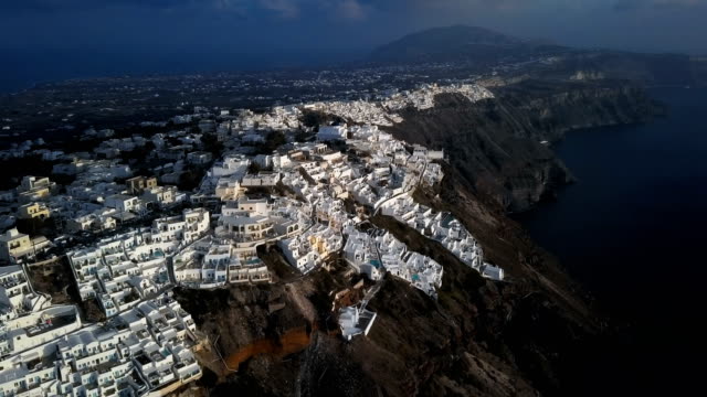 Sobrevuelo-de-pueblo-de-Imerovigli-y-roca-Skaros-en-puesta-del-sol,-isla-de-Santorini,-Grecia