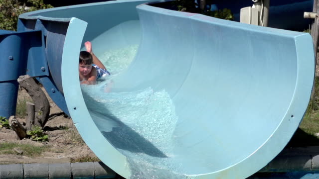 Slow-motion-of-happy-boy-on-water-slide,-South-Africa